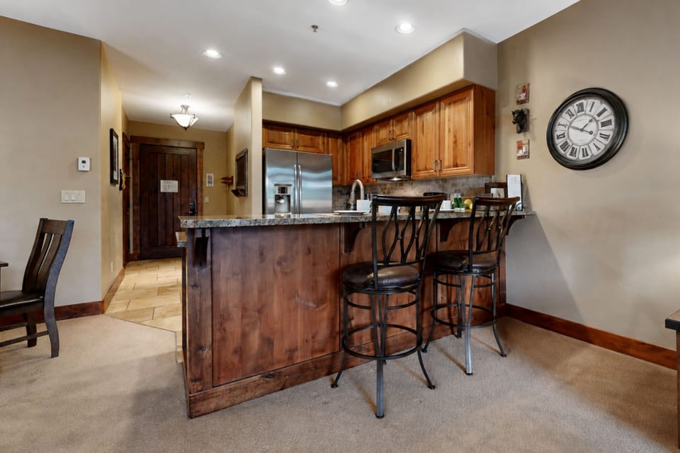 Step into your fully equipped kitchen with granite countertops, rich wood cabinetry, and stainless steel appliances. Gather around the island with seating for casual meals and morning coffee.