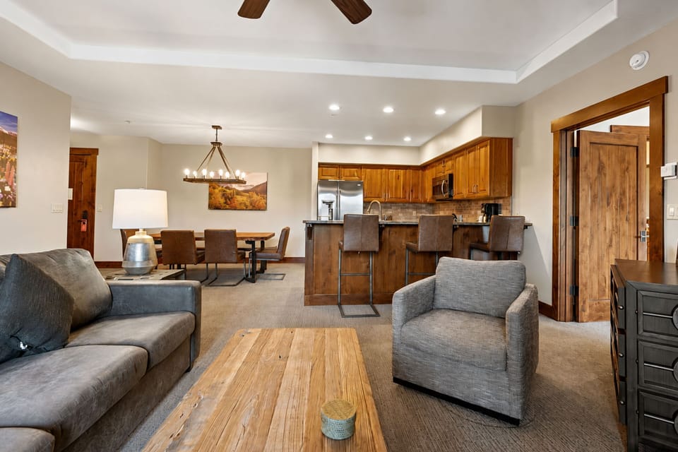 Settle into your inviting open-concept living space, where warm wood accents and comfortable seating create the perfect spot to unwind after mountain adventures.
