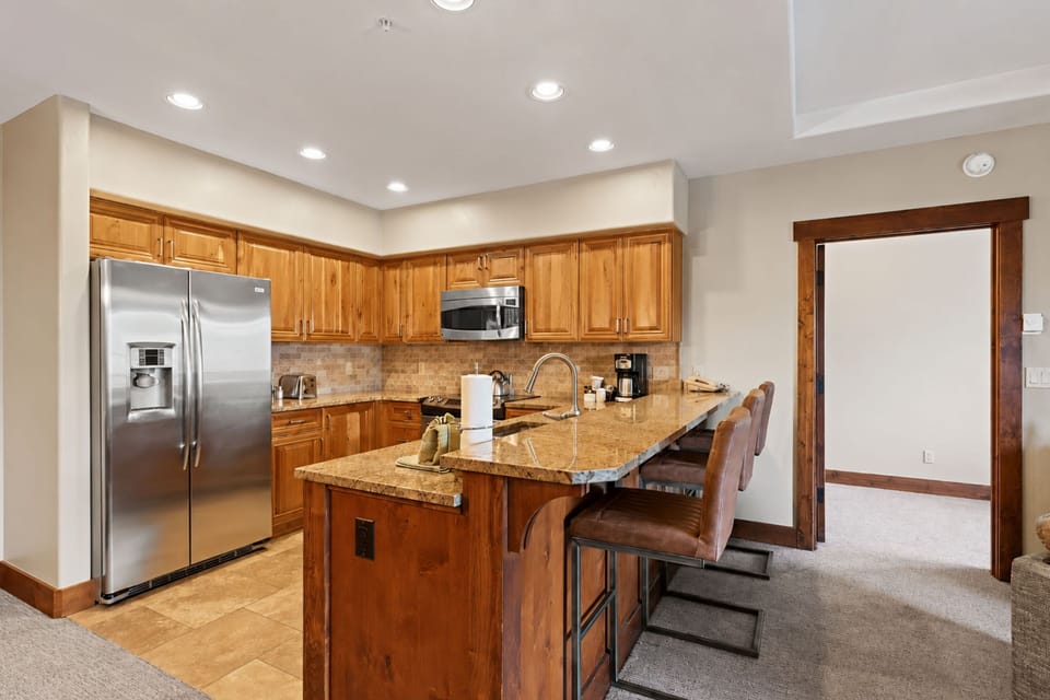 Your fully equipped kitchen invites you to prepare meals with ease, featuring warm wood cabinetry, granite counters, and stainless appliances. Gather at the island for morning coffee or casual dining in this welcoming space.