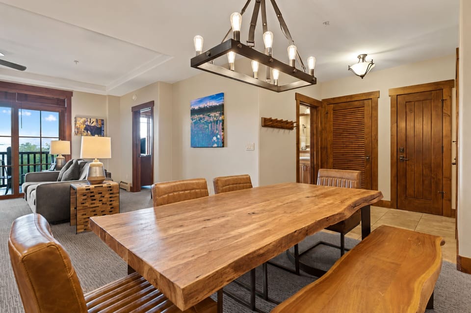 Gather around the stunning live-edge dining table under warm chandelier light. Your group will love this inviting space that flows effortlessly into the cozy living area, perfect for shared meals and laughter.