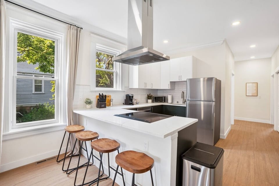 Spacious kitchen with breakfast-bar seating for four and large windows overlooking the trees.