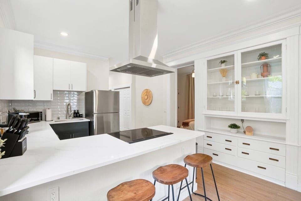 Bright kitchen with island seating, built-in cabinetry, and plenty of room for meal prep.