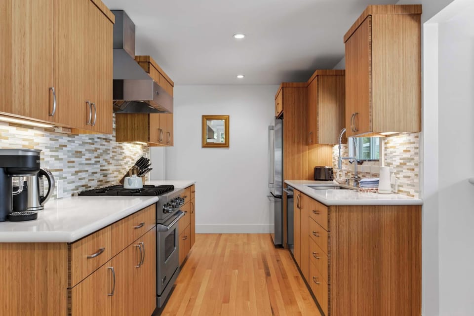 Cook on the stainless range at one end and rinse dishes at the other — this bright galley keeps everything within a few steps.