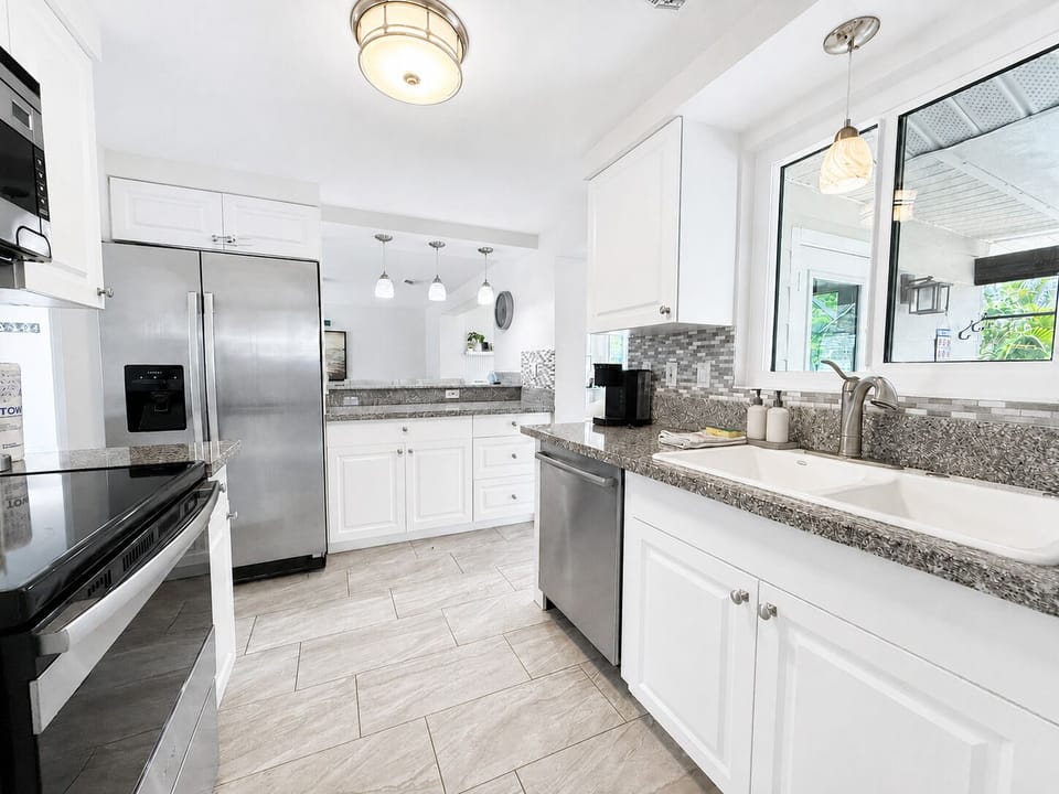 Bright modern kitchen with granite counters and stainless appliances