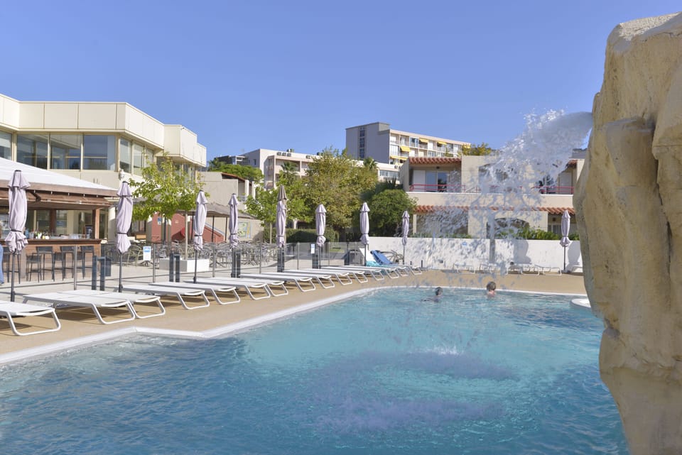 Seasonal lagoon-style pool with a waterfall feature.