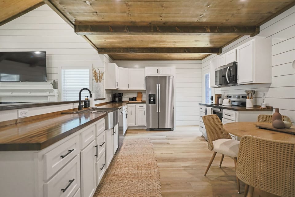 Bright farmhouse kitchen with wood beams, island seating, and cozy dining nook