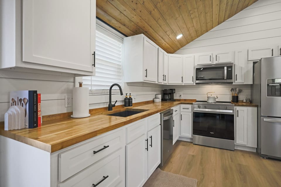 Bright modern kitchen with butcher block counters and vaulted wood ceiling