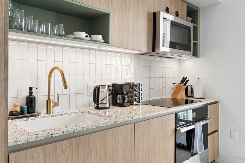 Well-equipped kitchen counter with coffee maker, toaster, and cooktop.