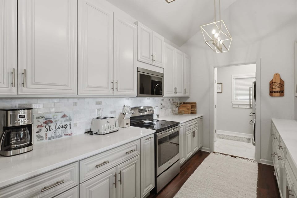 Bright, fully equipped kitchen with generous counter space, ample cabinetry, and modern stainless-steel appliances.