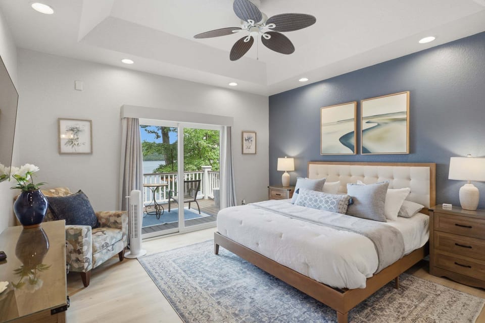 Spacious primary bedroom with a king bed, private deck access, and beautiful lake views.