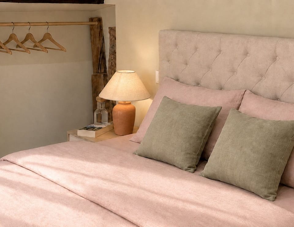Cozy bedroom with plush bedding, warm lighting, and stylish open storage