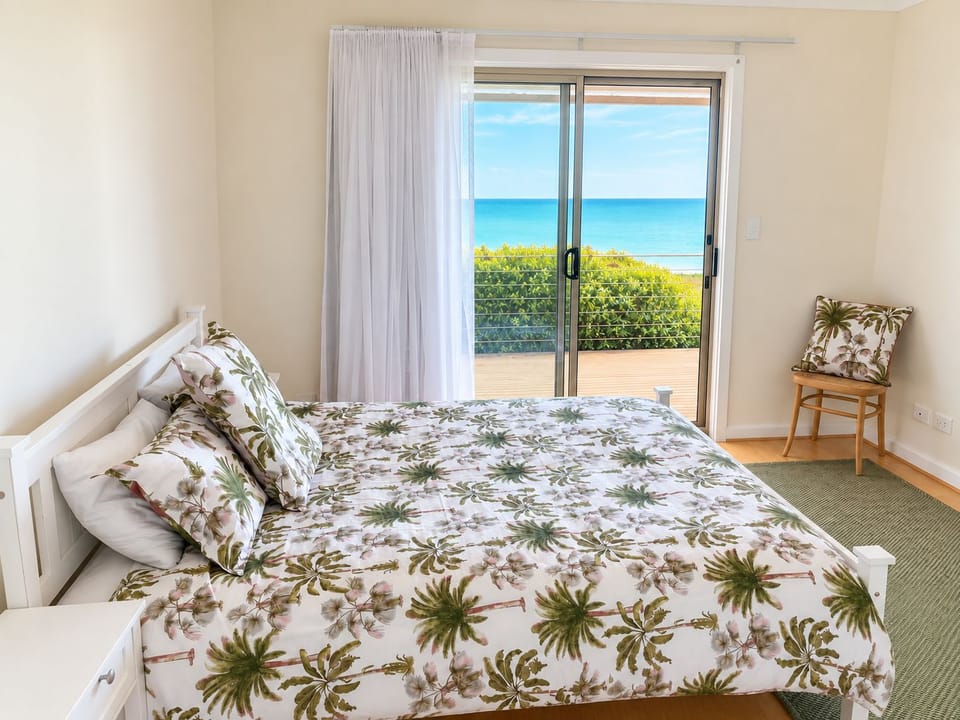 Bright coastal bedroom with private deck and beautiful ocean view