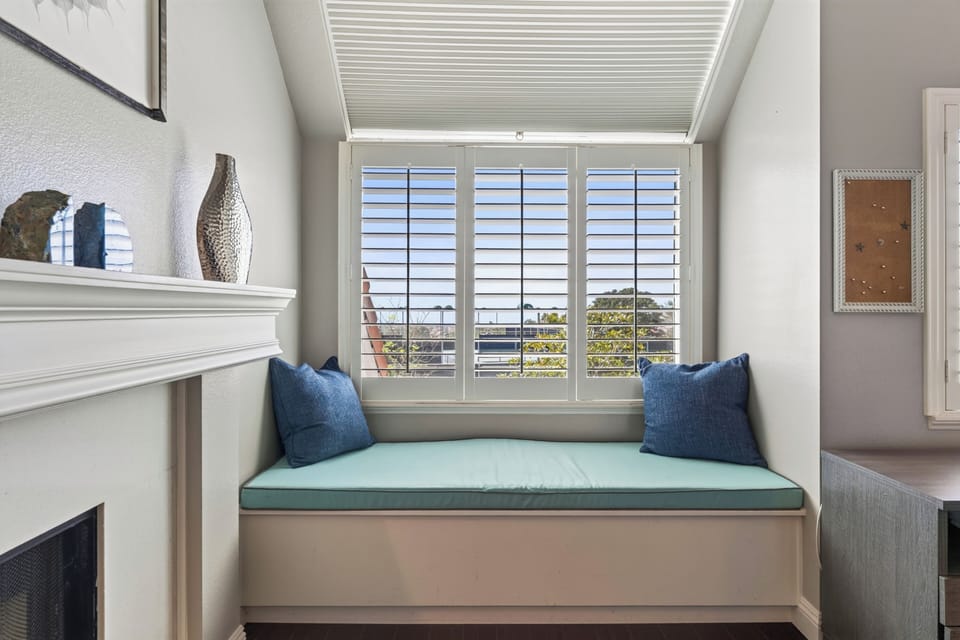 A sunlit window seat creates a peaceful corner for reading and relaxing in the primary suite.