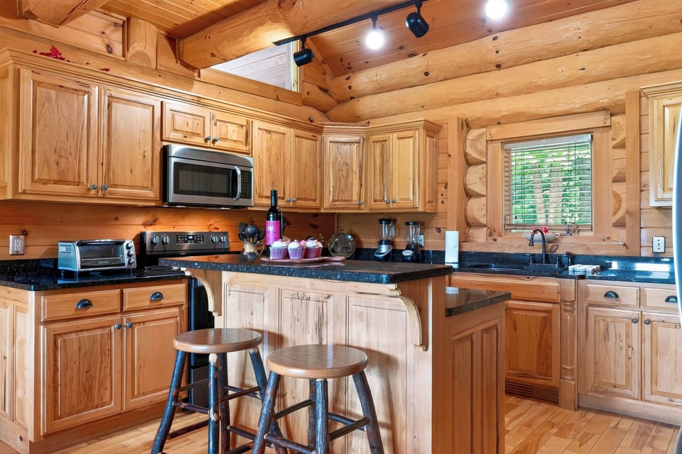 A warm wood kitchen pairs generous counter space with a center island and bar seating for casual meals and easy prep.