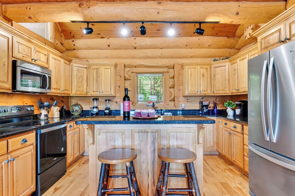 A warm wood kitchen pairs generous counter space with a center island and bar seating for casual meals and easy prep.