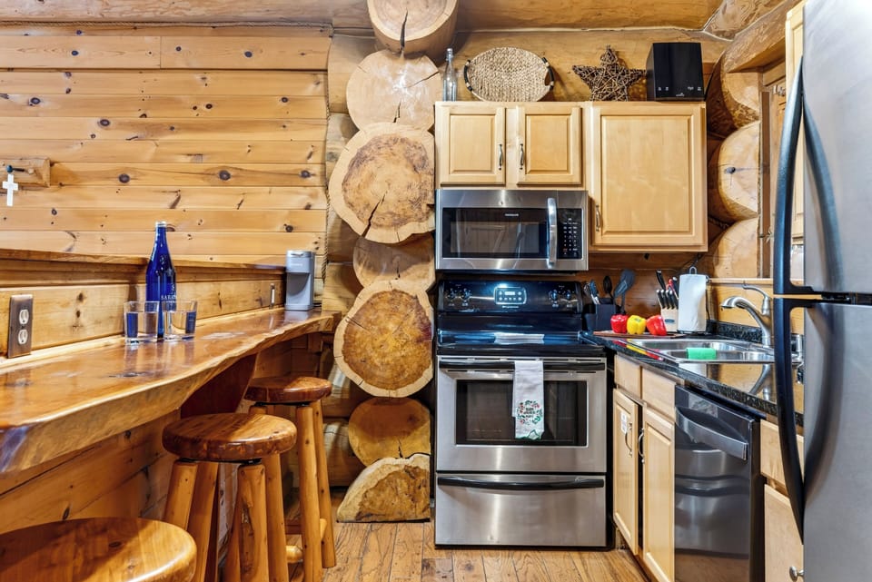 Kitchen with a breakfast bar and stainless steel appliances.