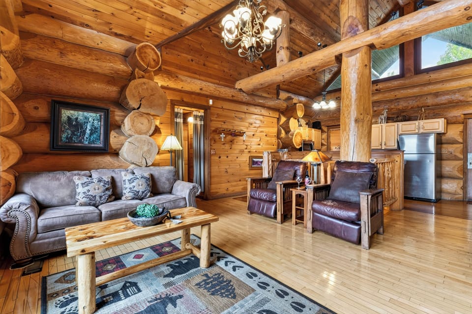 Open living area with log walls and comfortable seating.