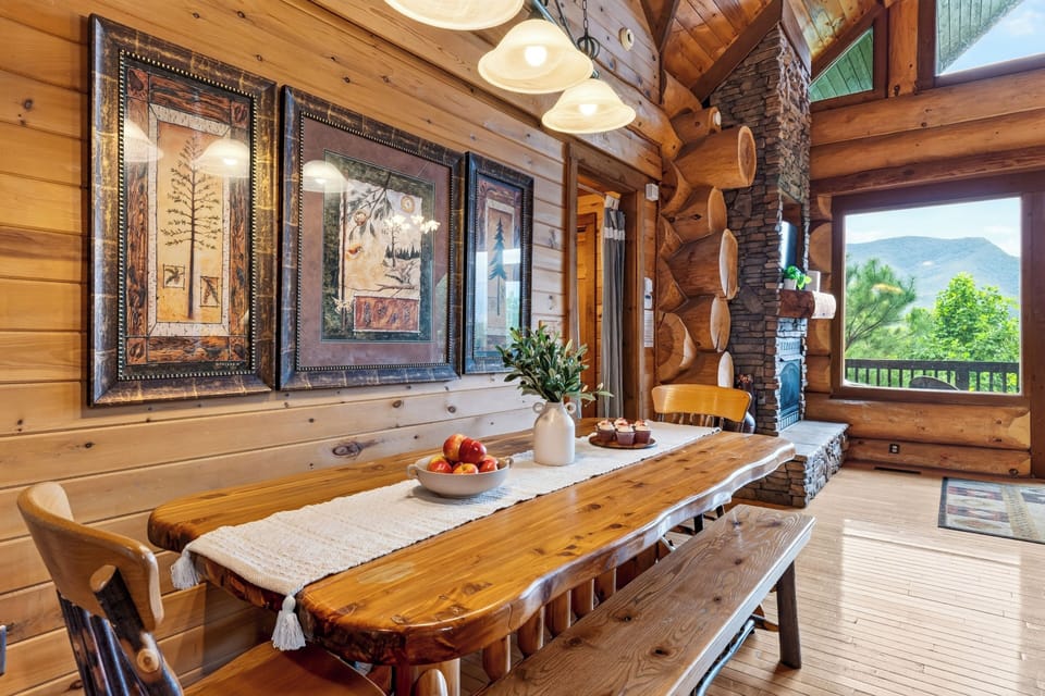 Rustic dining table with scenic views through large windows.
