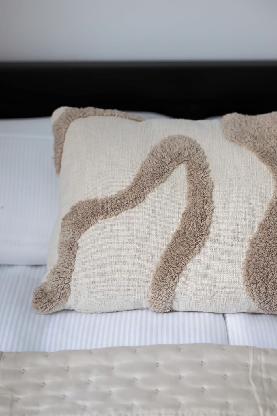 Bedroom featuring a neatly made bed with soft bedding and decorative cushions.