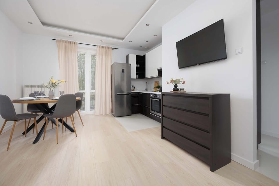 Spacious living room featuring modern furniture, light wooden flooring, and a comfortable seating area.