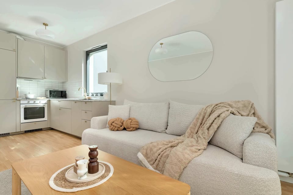 Elegant living room with a sofa, coffee table, and large windows.