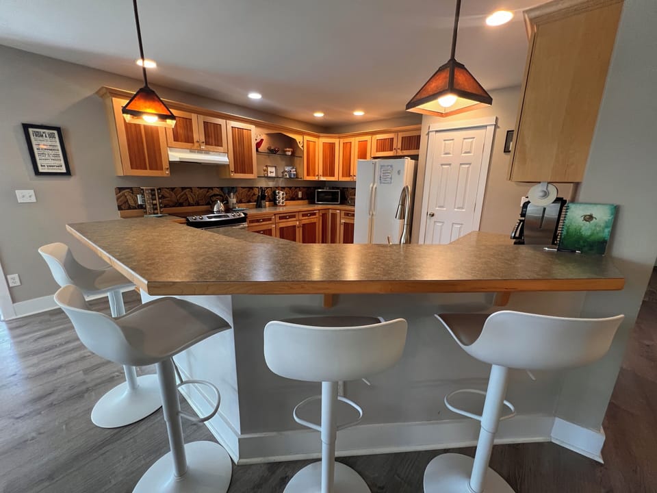 Your full kitchen awaits with beautiful wood cabinetry, modern appliances, and warm under-cabinet lighting—perfect for preparing meals and gathering with loved ones in this thoughtfully designed space.