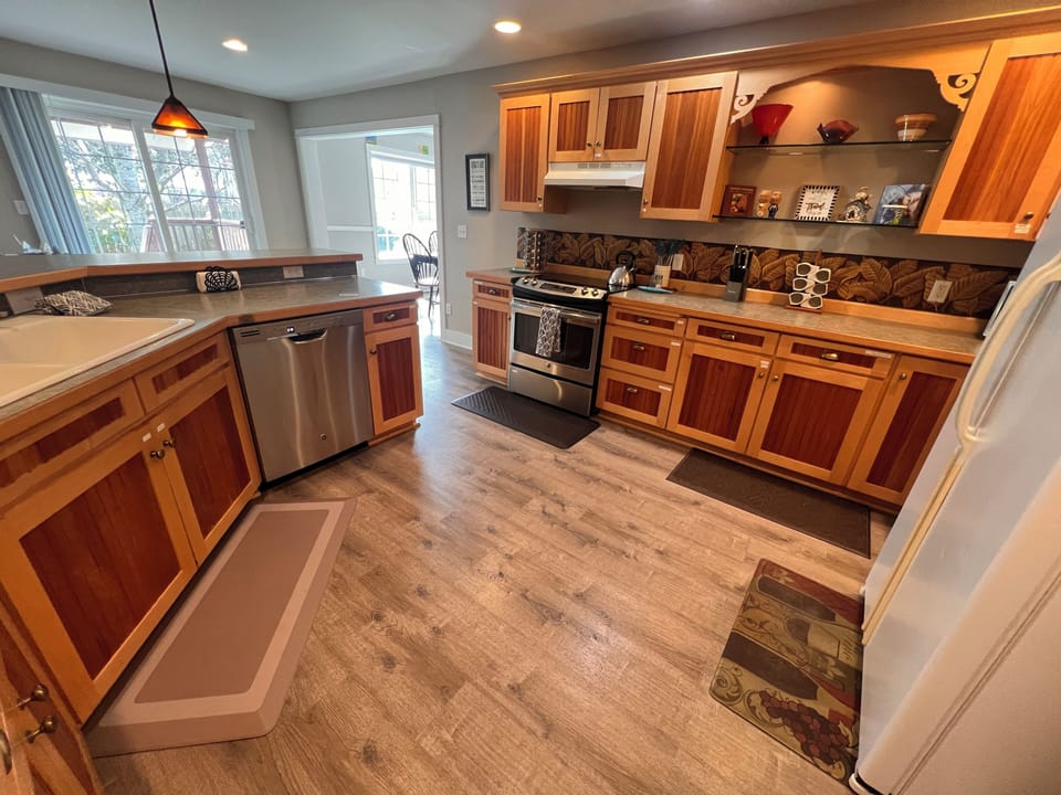 Step into your fully equipped kitchen where rustic wood cabinets meet modern appliances, and natural light pours in through charming windows. Cook, gather, and create memories under a beautifully textured ceiling that adds warmth to every meal.