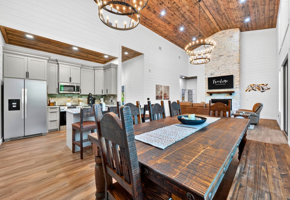 The dining area sits beneath a warm wood ceiling and opens directly into the kitchen, creating a comfortable space where everyone can linger a little longer.