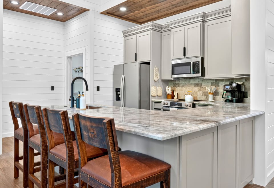 A spacious island with bar seating makes the kitchen an easy gathering spot, whether you are sharing breakfast, pouring drinks, or keeping the cook company.