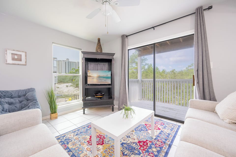 Natural light fills the living room as you unwind on cozy couches with a calming view from your balcony