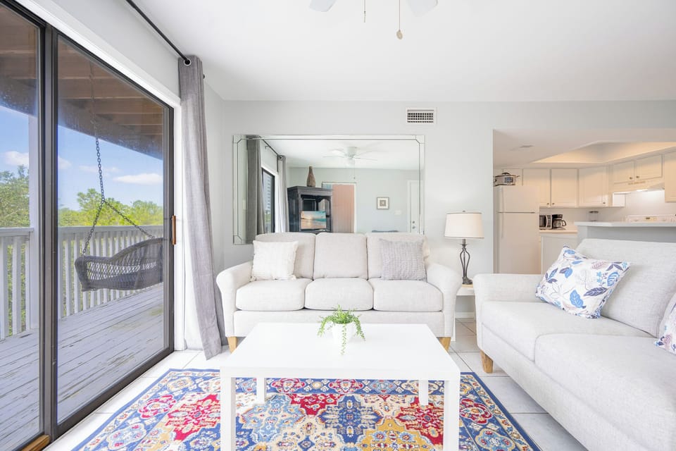 Bright living room invites you to relax on soft sofas while enjoying views from your balcony swing