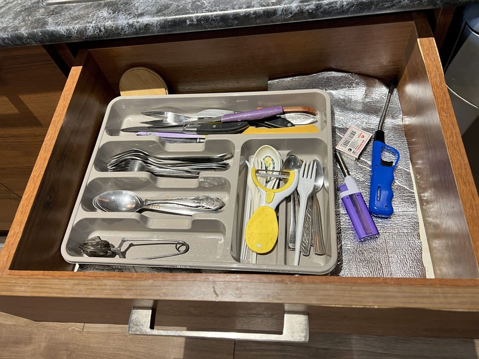 Cutlery drawer with utensils and kitchen tools.