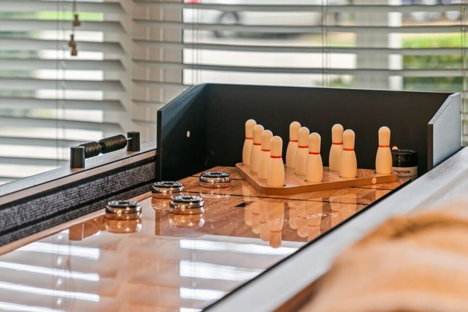 Indoor Game Room & Table Bowling: Host friendly tournaments right inside the home with this custom wooden table game setup featuring tabletop bowling and shuffleboard pucks, ideal for rainy-day entertainment and family fun.