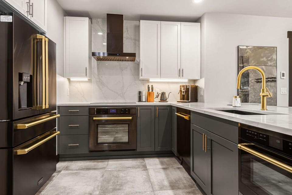 Your private kitchen gleams with modern style—crisp white marble, sleek dark cabinetry, and bright gold fixtures. Everything you need to whip up a meal or enjoy morning coffee in comfort.