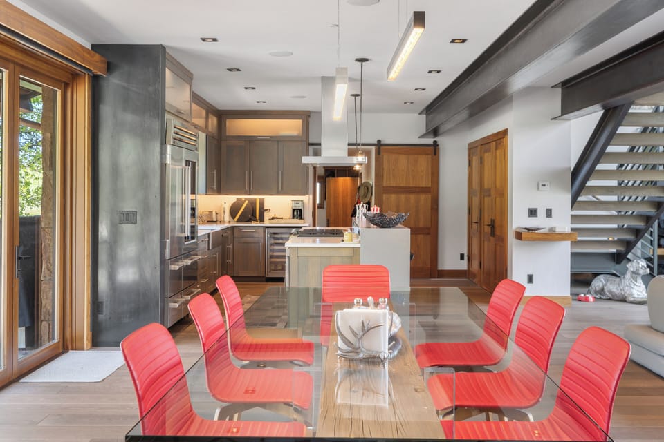 Step into an inviting open-concept space where modern design meets warm wood accents. Your dining area flows seamlessly into a fully equipped chef's kitchen, perfect for preparing memorable meals and gathering with loved ones during your stay.