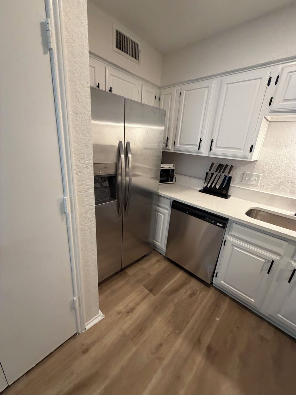 Bright modern kitchen with stainless appliances and crisp white cabinets