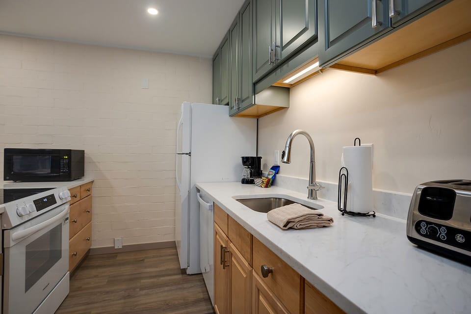 Your fully equipped kitchen invites you to prepare meals with modern appliances, ample counter space, and charming two-tone cabinetry that blends style with comfort.