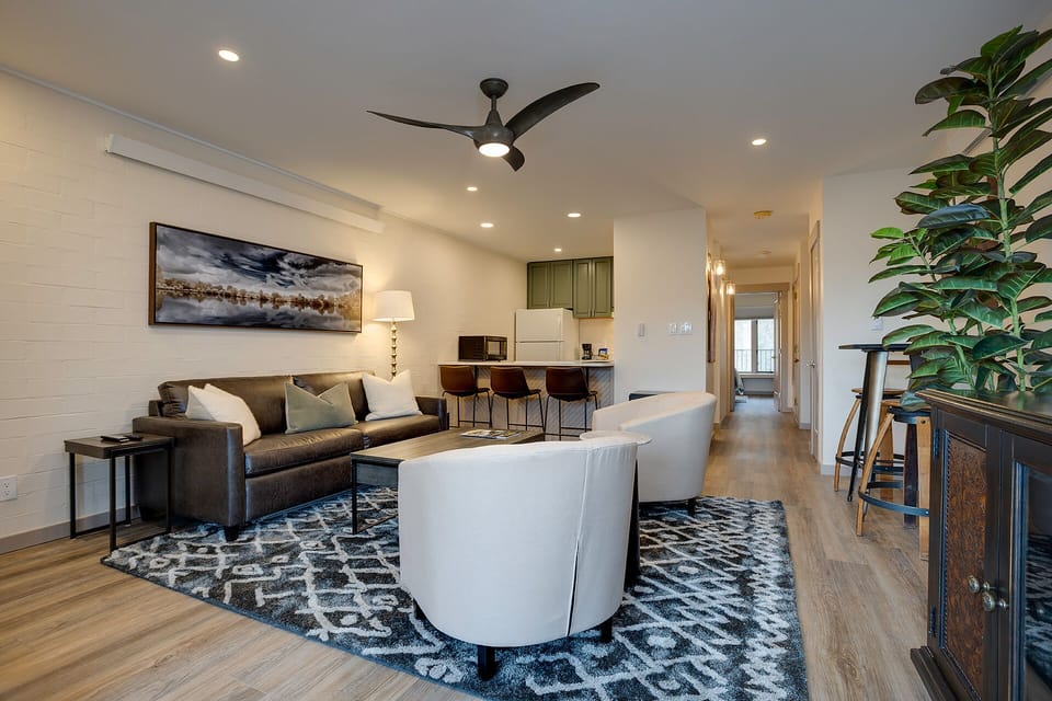Settle into your stylish living space, complete with plush seating, modern kitchen bar, and a bright, open layout perfect for relaxing or entertaining.