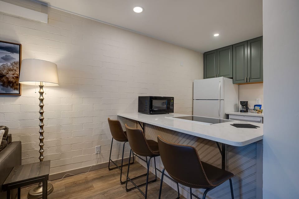 Your fully equipped kitchen features a sleek breakfast bar, perfect for morning coffee or casual meals, with modern appliances and elegant finishes throughout.