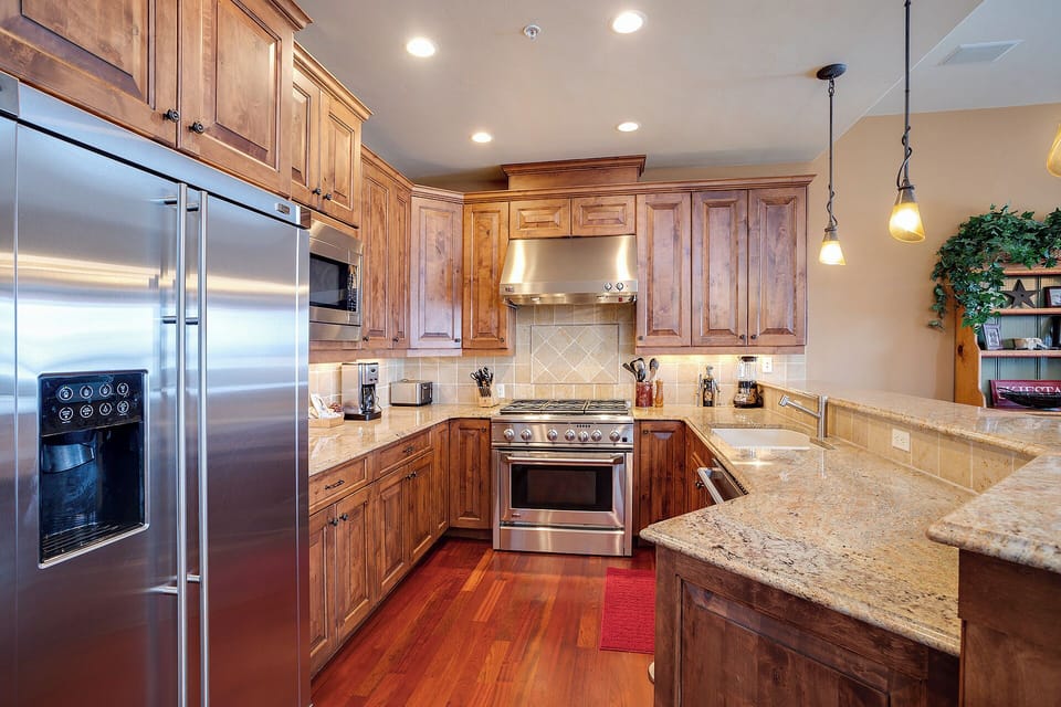 Your fully equipped kitchen awaits, featuring granite counters, stainless appliances, and warm wood cabinetry—everything you need to whip up a delicious meal during your stay.