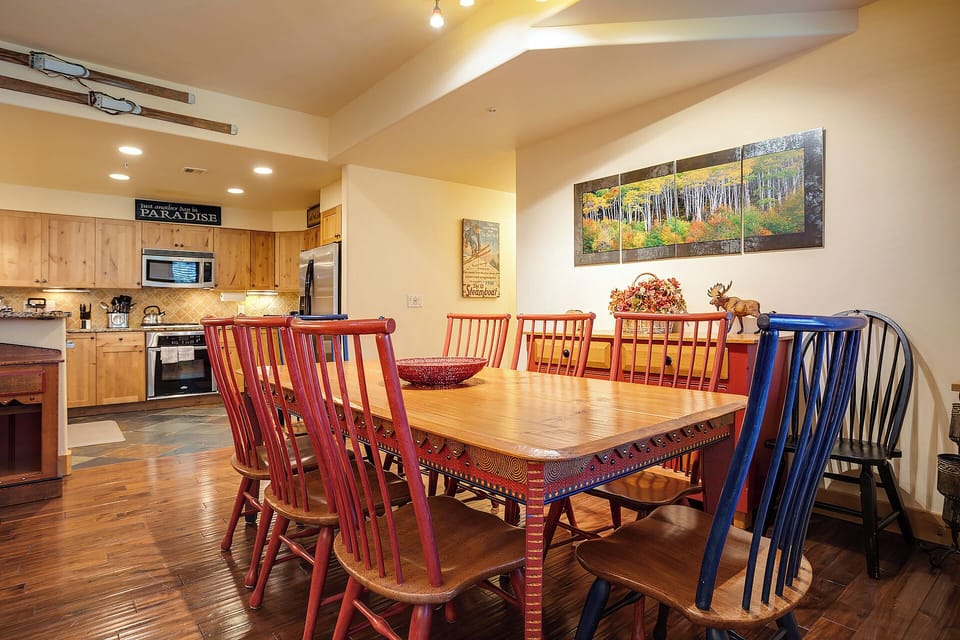 Gather around this inviting dining table with colorful seating for ten, perfectly positioned between your fully equipped kitchen and cozy living spaces for effortless entertaining.