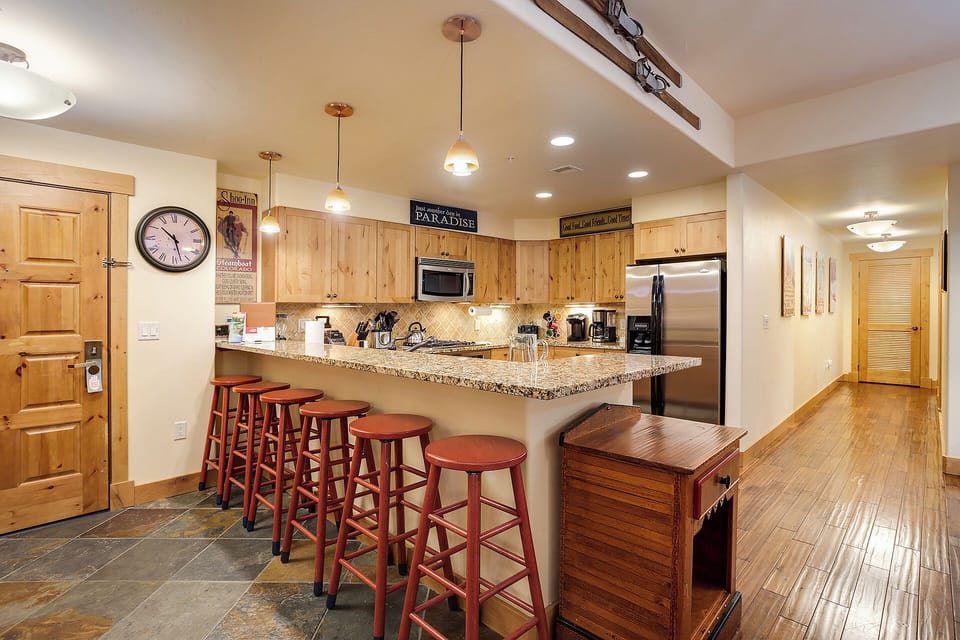 Gather around the spacious kitchen island with your group, where rich wood cabinetry, granite countertops, and stainless appliances create a welcoming space for cooking, dining, and making memories together.