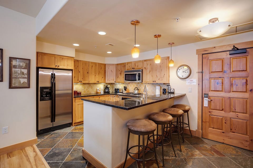 Your fully equipped kitchen awaits with sleek granite countertops, stainless steel appliances, and warm wood cabinetry. Gather at the breakfast bar for morning coffee or evening snacks in this inviting space.
