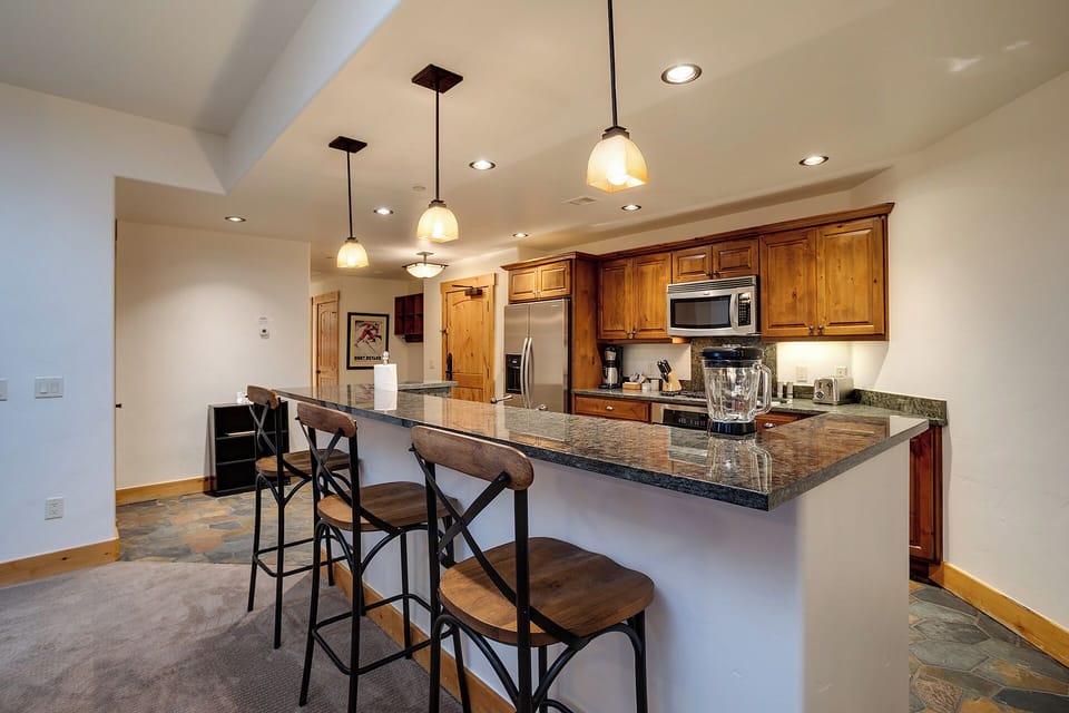 Gather around your spacious granite island with bar seating, perfect for morning coffee or casual meals. The fully-equipped kitchen features stainless steel appliances and rich wood cabinetry to make your stay feel like home.