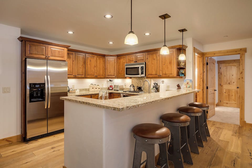 Your gourmet kitchen awaits with granite countertops, stainless steel appliances, and a spacious island perfect for gathering over morning coffee or preparing memorable meals together.