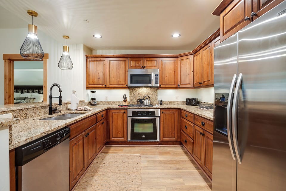 Your fully-equipped kitchen welcomes you with warm wood cabinetry, granite countertops, and stainless steel appliances—ready for crafting home-cooked meals in comfort and style.