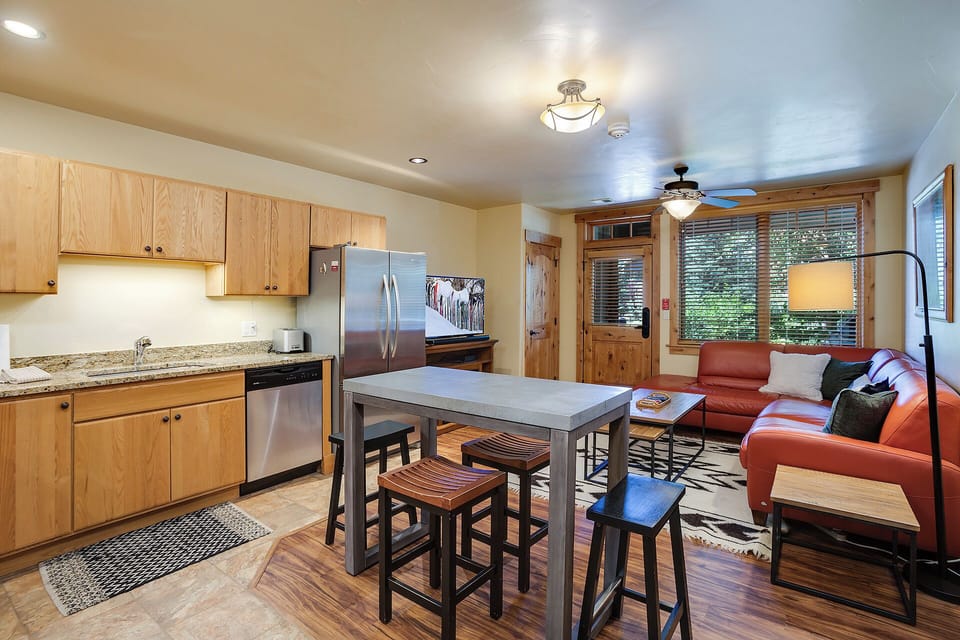 Step into your inviting open-concept space where a fully-equipped kitchen flows seamlessly into the living area. Gather at the high-top table with loved ones, unwind on plush seating, and enjoy all the comforts of home during your mountain getaway.