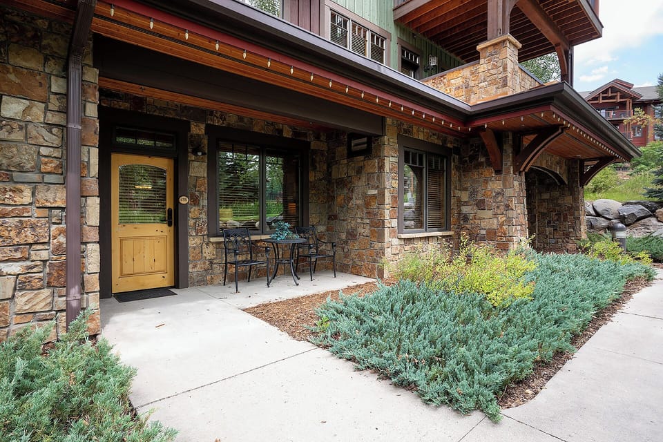 A charming stone facade with timber accents sets the tone for your mountain retreat. Step inside through the welcoming entrance, where string lights and a cozy patio invite relaxation.