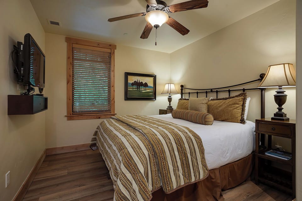 Your cozy retreat awaits with a plush bed, soft lighting, and a ceiling fan to keep you comfortable. Unwind with your favorite shows on the wall-mounted TV in this inviting space.
