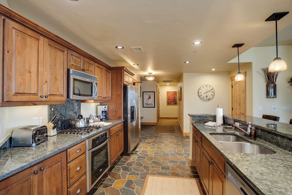 Your fully equipped kitchen features rich wood cabinetry, granite countertops, and stainless steel appliances—perfect for preparing home-cooked meals during your stay.